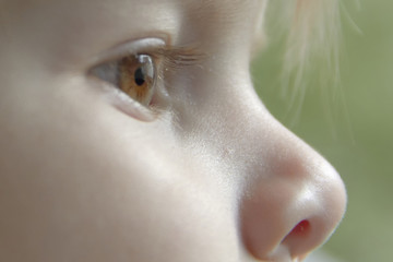 Close up of the face of a smiling little girl with blond hair in a car