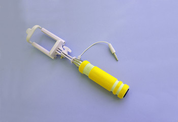 Selfie stick on a bright background, modern technology.