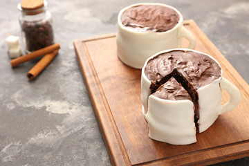 Chocolate cakes in shape of coffee cups on grunge background