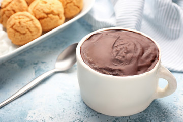 Chocolate cake in shape of coffee cup on color background