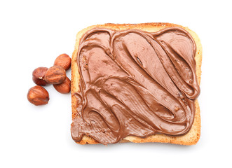 Fresh bread with tasty chocolate paste and hazelnuts on white background