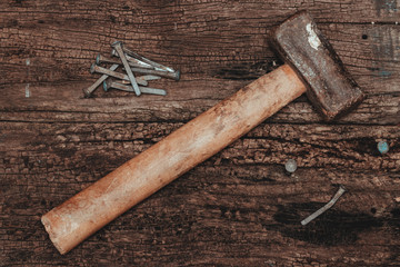 Hammer and nails over wood.