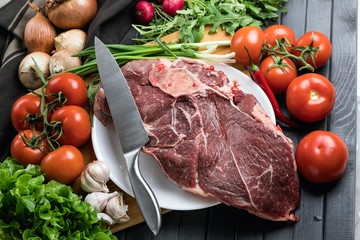 a piece of fresh choice beef lies on a wooden chopping Board. Fresh meat and vegetables Juicy steak with greens. Proper, balanced nutrition.
