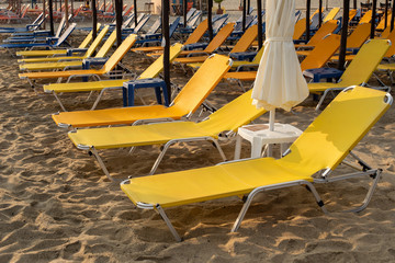 Yellow empty beach beds. Beach before sunrise.
