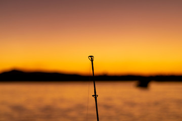 Closeup of fishing rod tip in the evening with plenty of copy space.