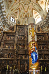 Retablo de monasterio con cirio pascual sobre el altar - obrazy, fototapety, plakaty
