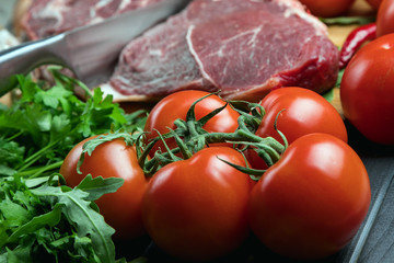 a piece of fresh choice beef lies on a wooden chopping Board. Fresh meat and vegetables Juicy steak with greens. Proper, balanced nutrition.