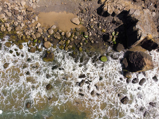 Ocean and rocky stone beach. Top view, texture and landscape.