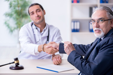 Male doctor in courthouse meeting with lawyer