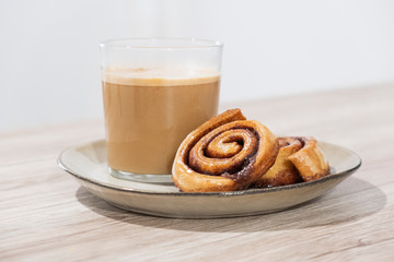 Desayuno repostería rollos de canela y café con leche