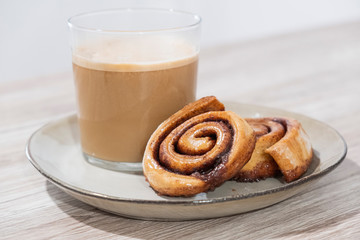 Desayuno repostería rollos de canela y café con leche