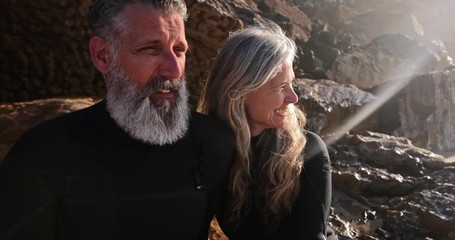 Close up senior man and woman by rocks at beach