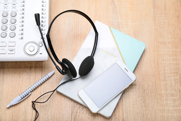 Headset, notebook and mobile phone on table of technical support agent