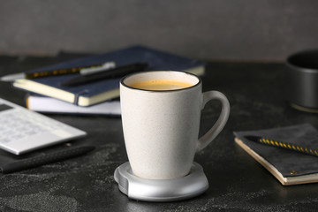 Cup of coffee with heater on table
