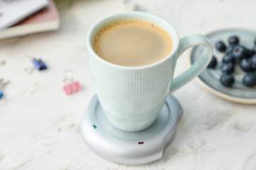Obraz na płótnie Canvas Cup of coffee with heater on table