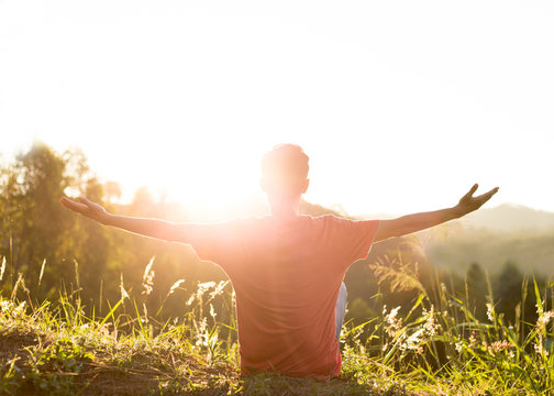 Feeling free. Happy young man with arms raised