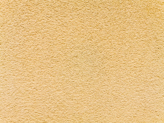 Texture or background of rough wall plastered with sand and cement in earthy tones 