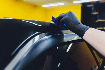 Car detailing - Man applies nano protective coating to the car. Selective focus.