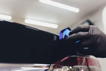 Car detailing - Man applies nano protective coating to the car. Selective focus.
