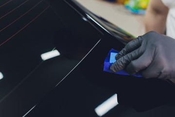 Car detailing - Man applies nano protective coating to the car. Selective focus.