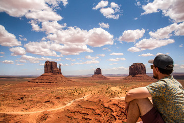 Man in summer time sitting on view point for Monument Valley in Arizona Utah United States of America. Travelling, road trip, adventure time.  © Scalia Media