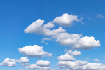Clear very bright blue sky with lots of white clouds.