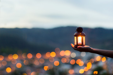 Fototapeta Moroccan lantern lit with city lights in the background obraz