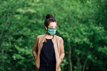 photo of a young woman in the forest wearing a face mask