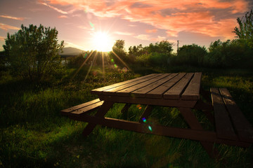 Isolated picnic table at a camping ground with a stunning pink & purple sunset on the longest day of the year, soltice, midnight sun Yukon Territory, Canada. 