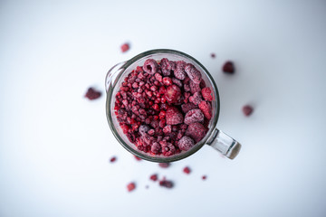 Himbeer Smoothie im Mixer, Vorbereitung für Smoothie, Aufsicht, rote gefrorene Beeren im Glas