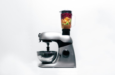 Smoothie Mixer mit bunten Früchten, Küchenmaschine vor weißem Hintergrund mit farbenfrohen...