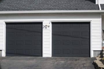 Two cars  Garage Door painted in black color in a typical single house.