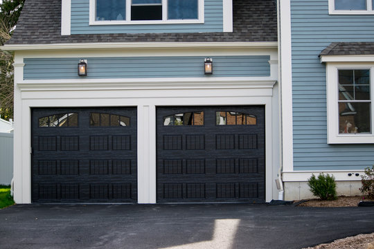 Two cars  Garage Doors painted in blackin a typical single house.