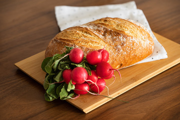 Bread and radish on a chopping board on the kitchen counter