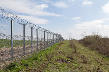Fototapeta na wymiar Border fence between Rastina (Serbia) & Bacsszentgyorgy (Hungary). This border wall was built in 2015 to stop the incoming refugees & migrants during the refugees crisis, on Balkans Route