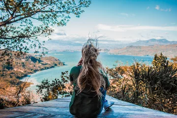 Foto op Plexiglas Jonge vrouw kijken naar het prachtige landschap van het meer tussen de bergen © FrediRomero