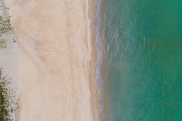 Fototapeta na wymiar Aerial view Top down of beautiful tropical beach Aerial drone shot of turquoise sea water surface at the beach space for text and summer background.