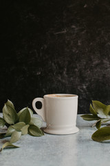 cup of coffee with leaves dark background