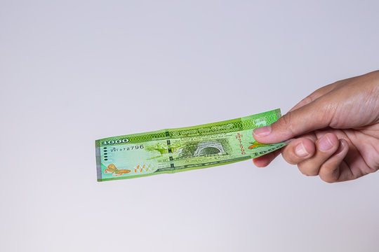 1000 Sri Lanka Rupees  banknotes in female hand. Woman's hands show Sri Lanka Rupie money. Girls hands holding money of Sri Lanka. Asian currency. Close up on Sri Lanka Rupee notes isolated on white