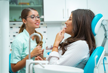 Obraz premium Patient and dentist talking, patient explaining the problem to the female doctor