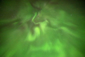 Astonishing, amazing northern lights aurora borealis seen in Yukon Territory, northern Canada in fall autumn. Looking directly up into the sky with green view & stars. 