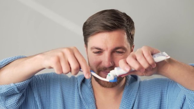 handsome man brushing his teeth