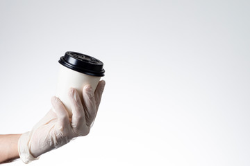 Delivery man holding with protective glove on white background disposable coffee cup.