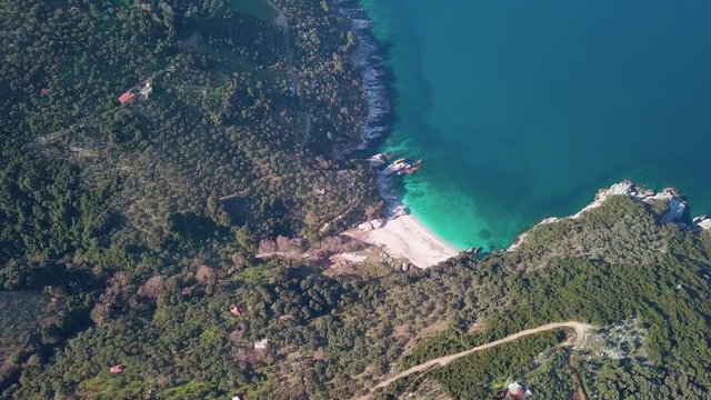 High angle drone shot over a beach with crystall clear water. 4K video quality