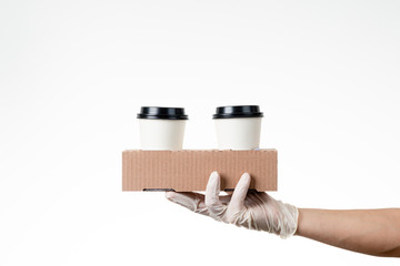 Detail of man with gloves holding disposable coffee cups. Delivery concept. Delivery service concept. Copy space.