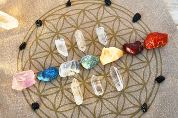 An close up image of chakra balancing stones on a sacred geometry grid cloth. 