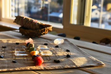 An close up image of chakra balancing crystals on a wooden table with glowing evening sunlight...