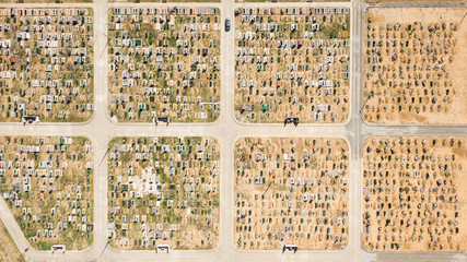 Aerial photo of new cemetery graveyard showing the headstones and tombstones of the graves some are with flowers long shadows from the coming sundown