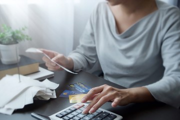 Hand of Asian woman pressing a calculator for check of bill, receipt, report, financial statement of credit card. Clear operate of internet banking, transfer money, order buy product, shopping online