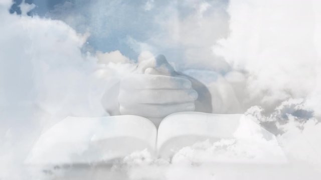 Animation of silhouette of Christian cross over mid section of person praying and reading holy Bible